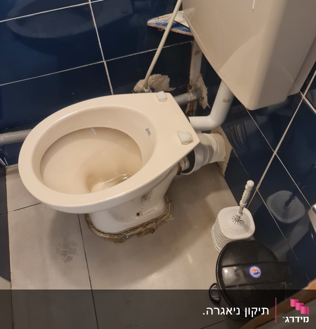 אסלה עם חיבורי צנרת גלויים ותיקונים סביב הבסיס